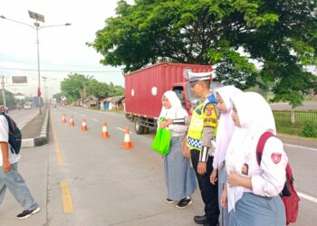 Personil Unit Lantas Polsek Pamanukan Seberangkan Anak Sekolah