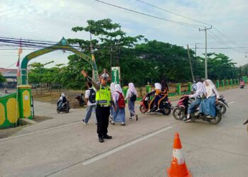 Berikan Pelayanan Prima pada Masyarakat, Personil Unit Lantas Polsek Pamanukan Seberangkan Anak Sekolah