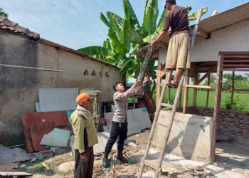 BHABINKAMTIBMAS BERSINERGI DENGAN MASYARAKAT GOTONG ROYONG MEMBANGUN SALAH SATU RUMAH WARGA